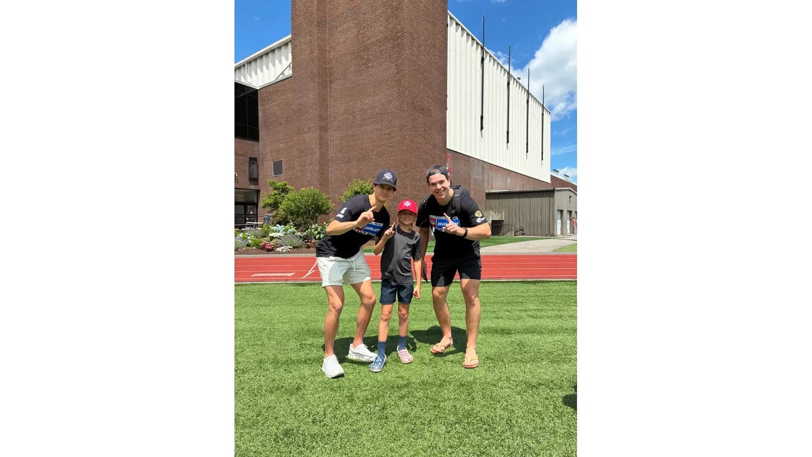 Coaches with a young camper on the Boston University turf