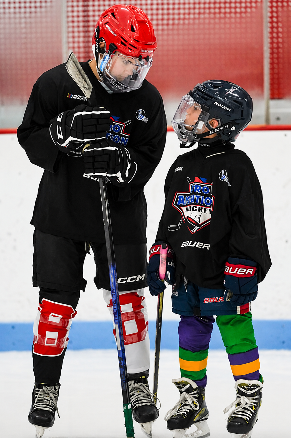 Pro Ambitions coach working with a young camper on the ice